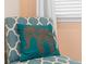 Close up image of a patterned chair with a teal, elephant design pillow at 8086 Knee Deep Rd, Kissimmee, FL 34747