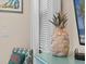 Decorative pineapple featuring shell textures, atop a teal blue dresser at 8086 Knee Deep Rd, Kissimmee, FL 34747