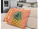 Close-up shot of a decorative pineapple pillow on a beige couch at 8086 Knee Deep Rd, Kissimmee, FL 34747