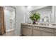 Bathroom with dual vanities, granite countertops, and large mirror, and a shower at 994 Lido Dr, Howey In The Hills, FL 34737