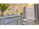 Well-lit bathroom featuring a granite countertop, gray cabinets, and modern fixtures at 994 Lido Dr, Howey In The Hills, FL 34737