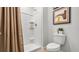 A new, bright bathroom with a tiled shower, toilet, and decorative plants at 994 Lido Dr, Howey In The Hills, FL 34737