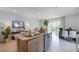 Modern kitchen island featuring a stainless steel sink, dishwasher, granite counters, and views into the adjacent living areas at 994 Lido Dr, Howey In The Hills, FL 34737