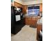 Traditional kitchen featuring wooden cabinets, tile flooring and a black appliance package at 103 Blue Heron Ln, Casselberry, FL 32707