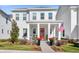 Charming two-story home featuring a well-manicured lawn and a welcoming front porch with a vibrant red door at 1073 Sadler Oaks Way, Winter Garden, FL 34787