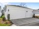 Spacious three-car garage with white doors and manicured landscaping at 1073 Sadler Oaks Way, Winter Garden, FL 34787