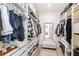 Organized walk-in closet with shelves, drawers, hanging rods, mirror and ottoman at 1073 Sadler Oaks Way, Winter Garden, FL 34787