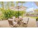 Relaxing backyard patio features an umbrella-shaded dining set surrounded by lush landscaping at 1145 Lake Rogers Cir, Oviedo, FL 32765