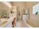 Well-lit bathroom with double vanities, a soaking tub, and a separate glass-enclosed shower at 1145 Lake Rogers Cir, Oviedo, FL 32765