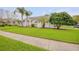 Landscaped front yard featuring lush green grass and mature trees complementing the home's facade at 1145 Lake Rogers Cir, Oviedo, FL 32765