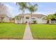 Inviting single-story home featuring a well-manicured lawn and mature palm trees enhancing curb appeal at 1145 Lake Rogers Cir, Oviedo, FL 32765