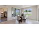 Dining area with a glass table, white chairs, a large window, and access to an adjacent bedroom space at 1214 Alstonia Ln, Mount Dora, FL 32757