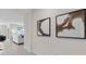 Hallway with decorative artwork leading to the living room, showcasing an open floor plan at 1214 Alstonia Ln, Mount Dora, FL 32757