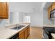 Kitchen area with wooden cabinets and view into bright living area at 13037 Mulberry Park Dr # 529, Orlando, FL 32821