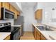 Kitchen featuring wood cabinets, stainless steel appliances, and a double sink at 13037 Mulberry Park Dr # 529, Orlando, FL 32821