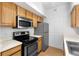 Kitchen showcasing wood cabinets, stainless steel microwave, and stainless refrigerator at 13037 Mulberry Park Dr # 529, Orlando, FL 32821