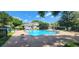 Community pool with ample deck space, surrounded by lush landscaping and mature trees on a sunny day at 13037 Mulberry Park Drive Dr # 529, Orlando, FL 32821