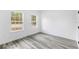 Neutral bedroom with gray wood-look flooring and natural light from two large windows at 13141 Sw 83Rd Ter, Ocala, FL 34473