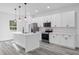 Bright kitchen features stainless steel appliances, a center island, and sleek white cabinets at 13141 Sw 83Rd Ter, Ocala, FL 34473