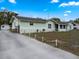 Side view of a cozy home with a spacious concrete driveway and a small storage shed at 1512 N Hastings St, Orlando, FL 32808