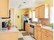 Well-lit kitchen featuring wood cabinets, modern appliances, granite countertops, and tile flooring at 1512 N Hastings St, Orlando, FL 32808