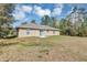 Backyard view of home featuring a sliding glass door and lots of trees at 16121 Sw 24Th Court Rd, Ocala, FL 34473