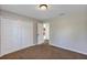 A well-lit bedroom with neutral walls, plush carpet, and a closet with bi-fold doors at 16121 Sw 24Th Court Rd, Ocala, FL 34473