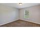 A cozy bedroom with neutral walls, plush carpet, and a bright window at 16121 Sw 24Th Court Rd, Ocala, FL 34473