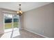 Bright dining area with tile flooring, chandelier, and sliding glass door to backyard at 16121 Sw 24Th Court Rd, Ocala, FL 34473