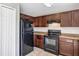 A well-lit kitchen with stainless steel appliances and dark wood cabinetry at 16121 Sw 24Th Court Rd, Ocala, FL 34473