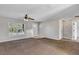 Well-lit living room with carpet, ceiling fan, and a view of the front door at 16121 Sw 24Th Court Rd, Ocala, FL 34473