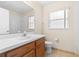 Bright bathroom featuring a single sink vanity, white tile shower, and window for natural light at 2422 Black Powder Ln, Kissimmee, FL 34743