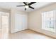 Cozy bedroom featuring tile flooring, ceiling fan, a closet, and a bright window at 2422 Black Powder Ln, Kissimmee, FL 34743