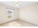 Cozy bedroom with tiled floors, neutral paint, a ceiling fan, and a bright window at 2422 Black Powder Ln, Kissimmee, FL 34743