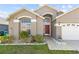 Charming single-story home featuring a well-manicured lawn and a two-car garage at 2422 Black Powder Ln, Kissimmee, FL 34743