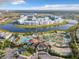 Aerial view of a community, showcasing pools, community waterpark, lake, and condo buildings at 2573 Reading Trl, Kissimmee, FL 34746