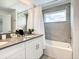 Clean bathroom featuring a shower-tub combo with modern tiling and white vanity at 2573 Reading Trl, Kissimmee, FL 34746