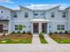 Stylish townhomes featuring a modern design with red doors, fresh landscaping and a sidewalk at 2573 Reading Trl, Kissimmee, FL 34746