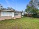 Spacious backyard featuring a well-maintained lawn, mature trees, and partial privacy fencing at 2805 Grassmere Ln, Orlando, FL 32808