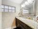 Well-lit bathroom featuring granite countertops, a dark wood cabinet, and a large mirror at 2805 Grassmere Ln, Orlando, FL 32808