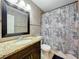 Bathroom featuring granite countertops, a black framed mirror, and tiled shower with curtain at 2805 Grassmere Ln, Orlando, FL 32808