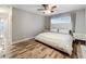 A bright bedroom featuring wood floors, neutral walls, a ceiling fan, and a comfortable bed at 2805 Grassmere Ln, Orlando, FL 32808