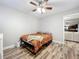 Bedroom featuring wood-look floors, ceiling fan and access to other rooms in the home at 2805 Grassmere Ln, Orlando, FL 32808