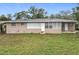 Charming single-story home featuring a neutral-toned brick exterior and large windows providing ample natural light at 2805 Grassmere Ln, Orlando, FL 32808