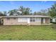 Charming single-story home featuring a neutral-toned brick exterior and large windows providing ample natural light at 2805 Grassmere Ln, Orlando, FL 32808