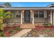 Close up of welcoming front porch with decorative brickwork, lighting, and a secure, steel entry door at 2805 Grassmere Ln, Orlando, FL 32808