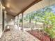 Covered front porch with decorative tile, white columns, and a well-landscaped yard providing a relaxing outdoor space at 2805 Grassmere Ln, Orlando, FL 32808