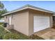 Attached garage featuring a large white door and matching brickwork exterior and side entry door at 2805 Grassmere Ln, Orlando, FL 32808