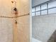 Close up of a tiled shower with shower head and soap caddy with decorative tile border at 2805 Grassmere Ln, Orlando, FL 32808