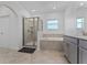 Well-lit bathroom showcasing a glass shower, soaking tub, and gray vanity at 2977 Howley Aly, St Cloud, FL 34771